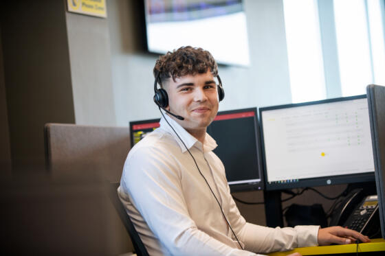 alt="male call centre operator wearing headset"