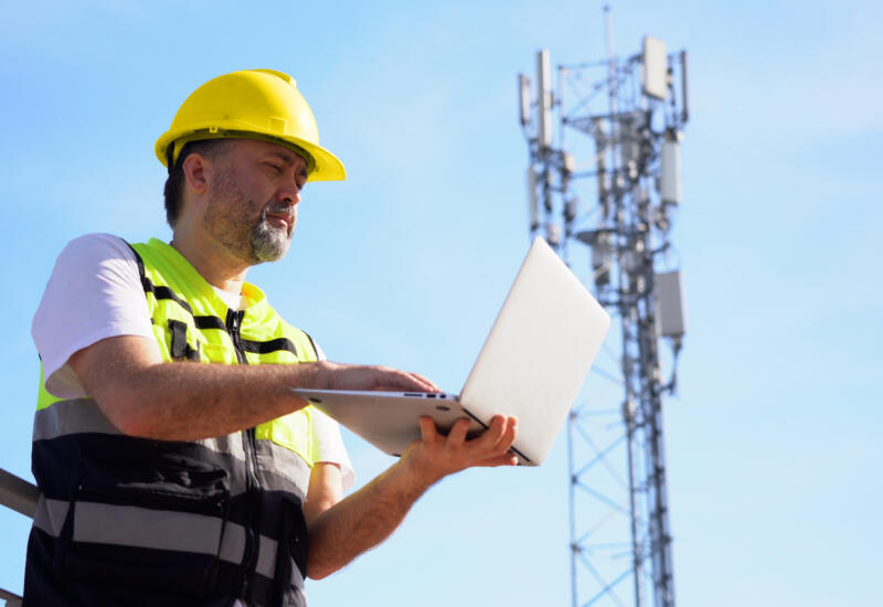 alt="telecoms engineer using laptop support"